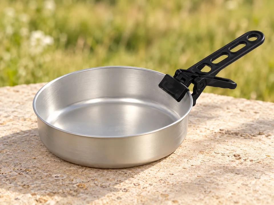 Cao — popote scout en aluminium — Détail de deux éléments : le faitout ouvert et sa pince noire ; le reste de la popote n’est pas représenté.