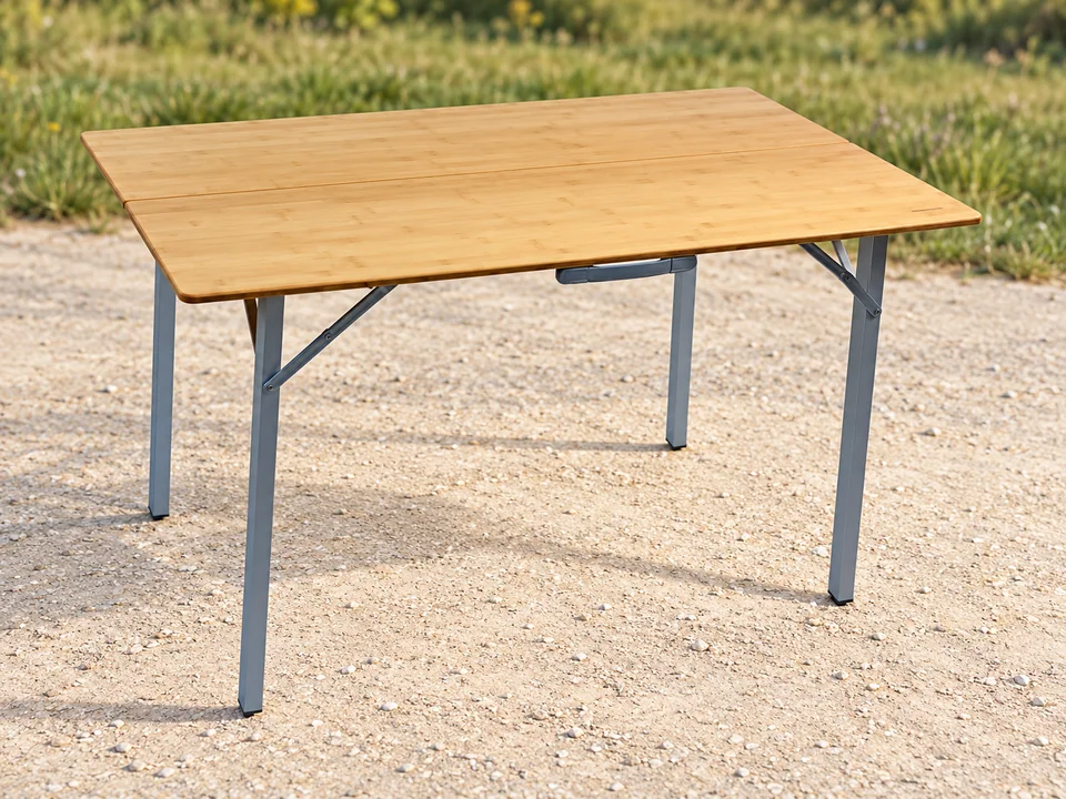 Soplair Bamboo — table valise en bambou — Plateau blond à joint longitudinal, quatre pieds gris carrés, poignée et renforts diagonaux comparés ; table seule sans housse ajoutée.