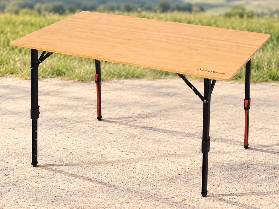 KingCamp — table bambou à quatre plis — Bambou clair, pieds télescopiques noirs avec éléments rouges et renforts conservés ; encarts commerciaux, seconde vue pliée et badge retirés. Table seule vide.